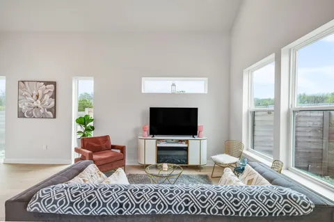 a living room with furniture a flat screen tv and a fireplace