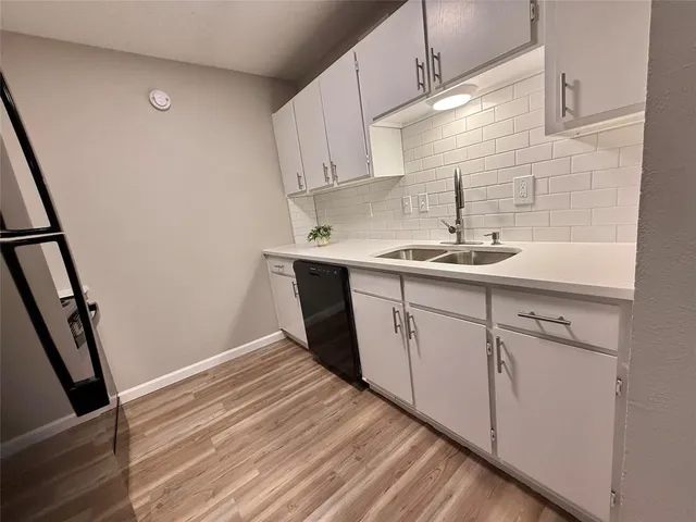 a kitchen with a sink a window and cabinets