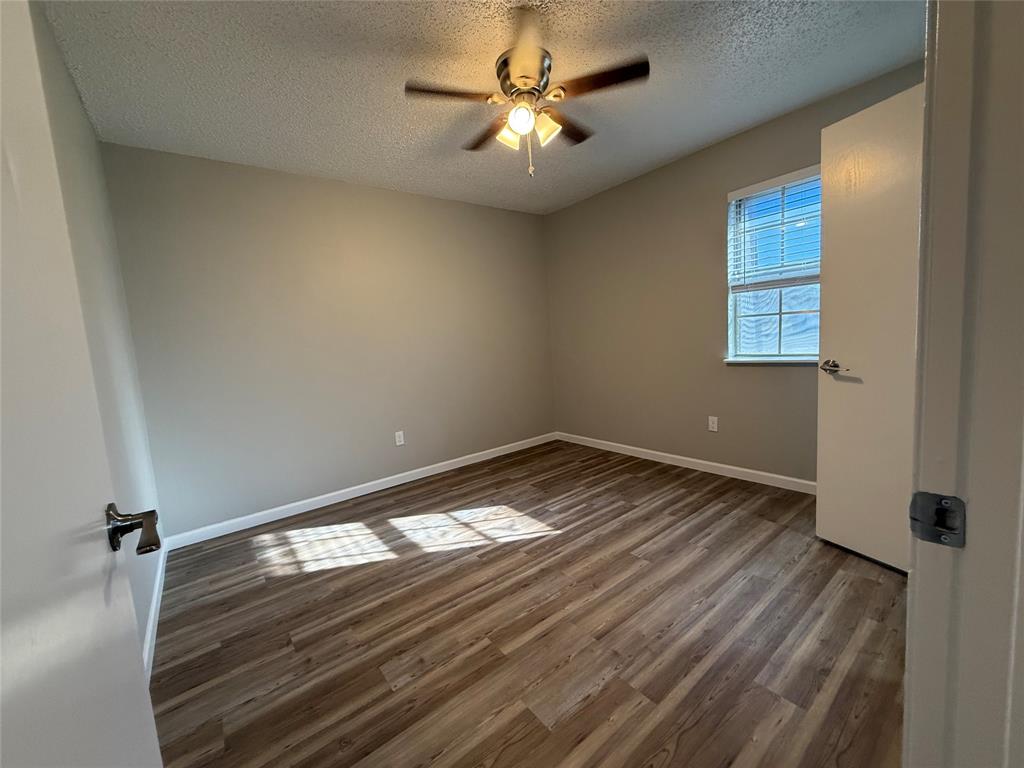 629 Central Avenue, Unit 202 Newark, TX 76071 - Photo 11 of 19 a view of empty room with wooden floor and fan