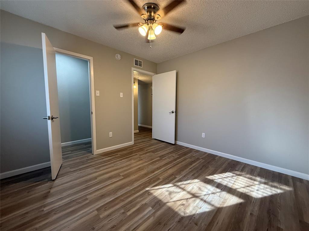 629 Central Avenue, Unit 202 Newark, TX 76071 - Photo 13 of 19 a view of a livingroom with a chandelier fan and wooden floor