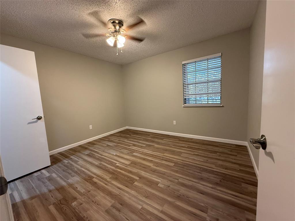 629 Central Avenue, Unit 202 Newark, TX 76071 - Photo 14 of 19 wooden floor in an empty room with a window
