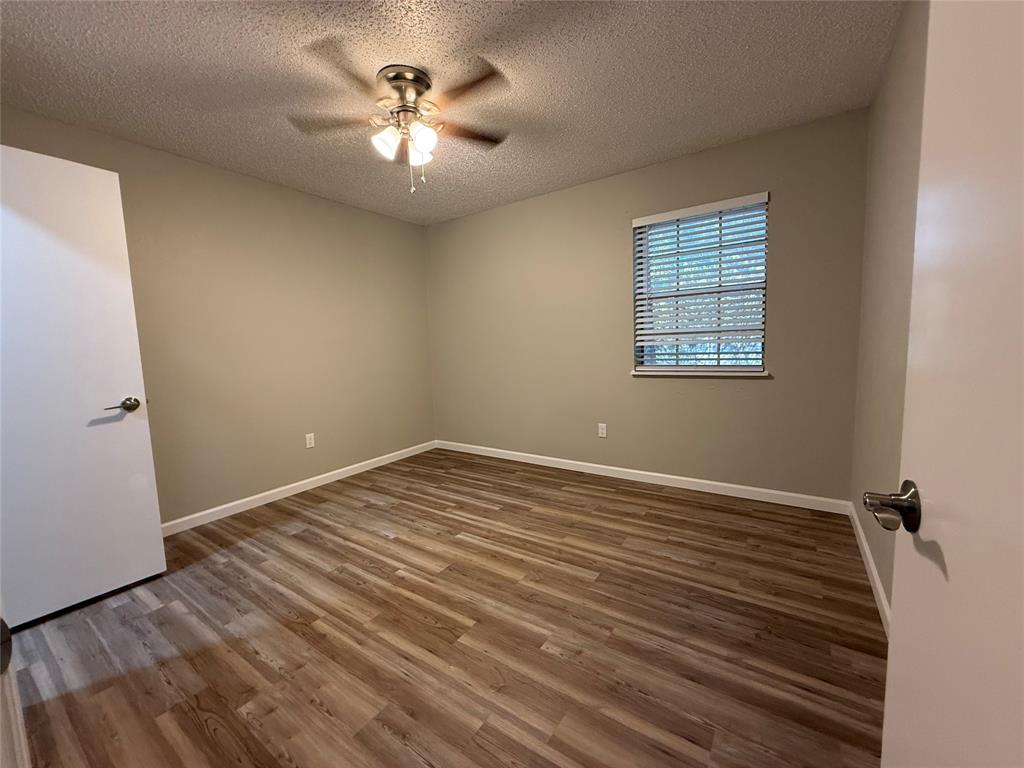 629 Central Avenue, Unit 202 Newark, TX 76071 - Photo 15 of 19 wooden floor in an empty room with a window