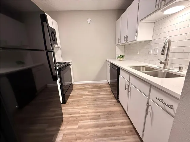 a kitchen with sink a refrigerator and washer