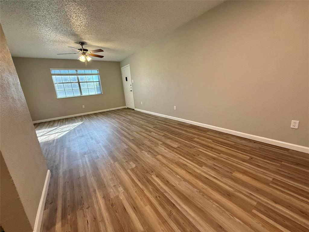 629 Central Avenue, Unit 202 Newark, TX 76071 - Photo 4 of 19 wooden floor in an empty room with a window