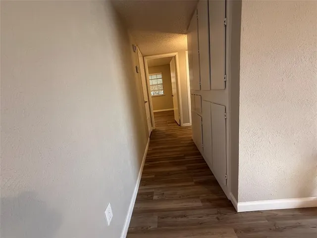 a view of a hallway with a wooden floor and entryway