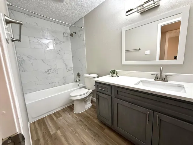 a bathroom with a sink a toilet a mirror a bathtub and shower