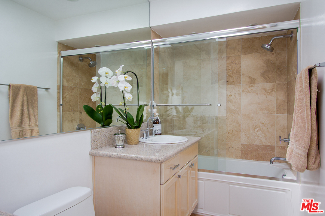 2267 Roscomare Road Los Angeles, CA 90077 - Photo 13 of 31 a bathroom with a sink a mirror a bathtub and a shower
