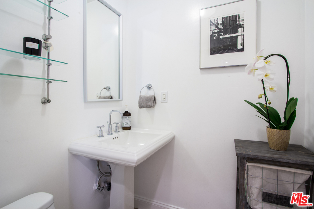 2267 Roscomare Road Los Angeles, CA 90077 - Photo 15 of 31 a bathroom with a sink a mirror and a potted plant