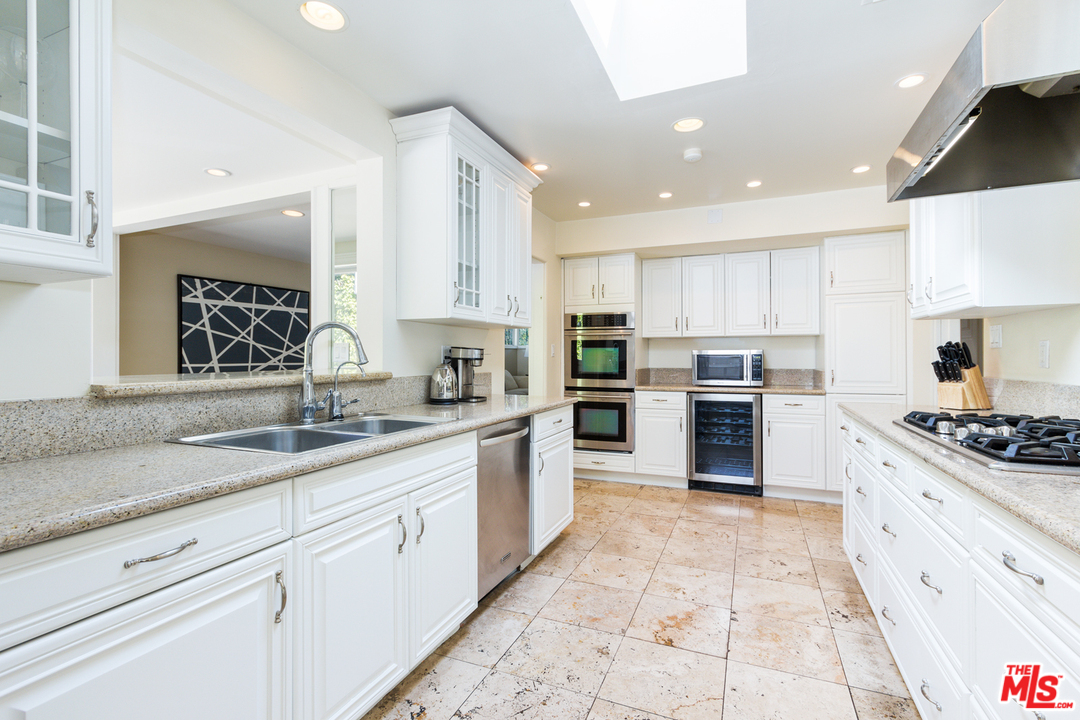 2267 Roscomare Road Los Angeles, CA 90077 - Photo 4 of 31 a kitchen with granite countertop white cabinets stainless steel appliances and a counter space