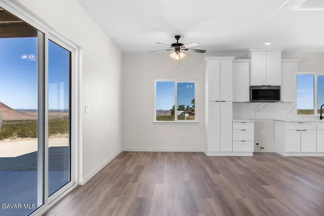 a view of a kitchen with a microwave and wooden floor