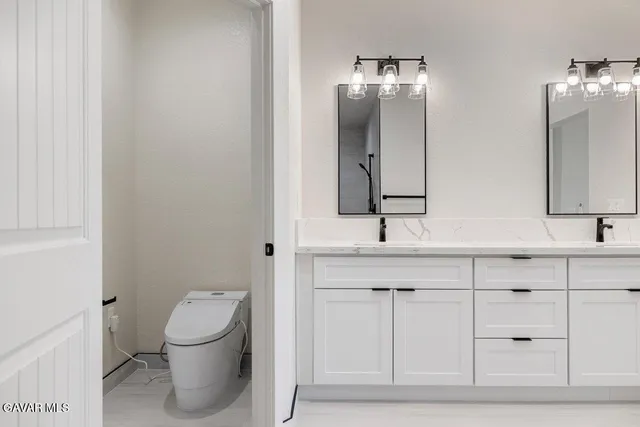a bathroom with a toilet sink and mirror