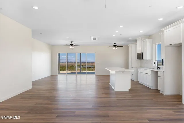 a open kitchen with white cabinets and stainless steel appliances