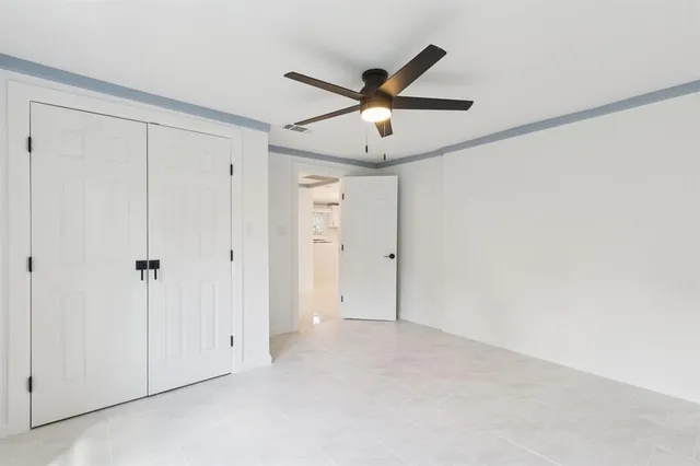 a view of empty room with window and ceiling fan