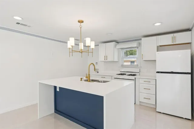 a kitchen with appliances a sink and a refrigerator