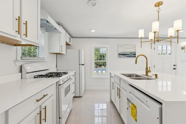a kitchen with stainless steel appliances granite countertop a sink stove and cabinets