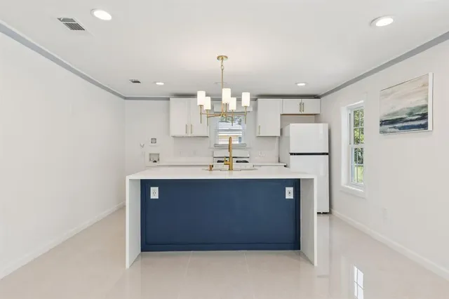 a kitchen with kitchen island a sink stainless steel appliances and cabinets