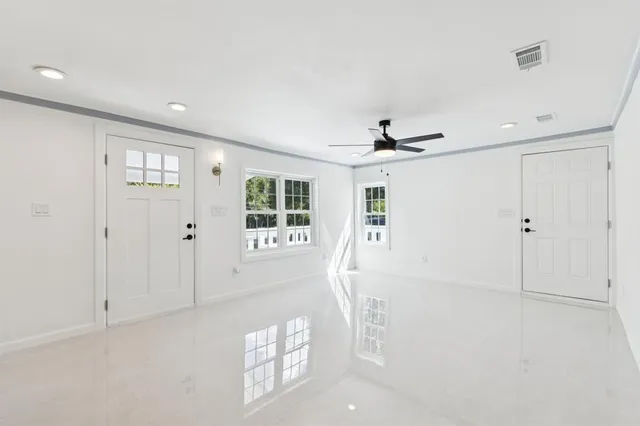 a living room with stainless steel appliances kitchen island granite countertop a refrigerator a sink a stove and a window