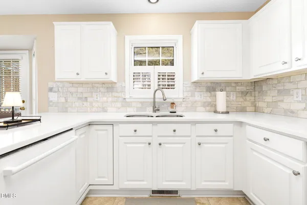 a kitchen with a sink cabinets and window
