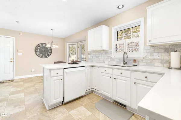 a kitchen with granite countertop white cabinets and white appliances