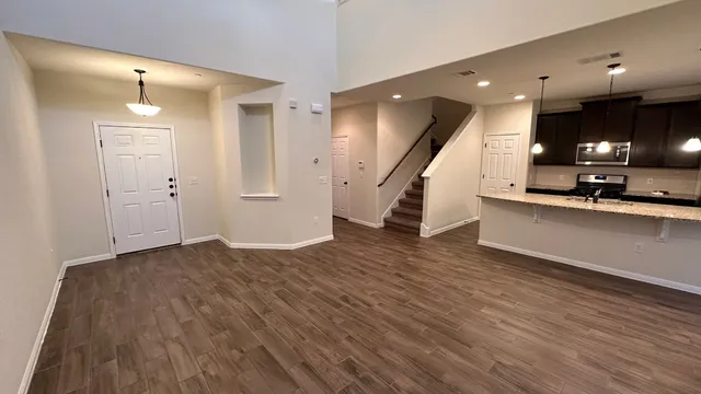 wooden floor in an empty room with a kitchen
