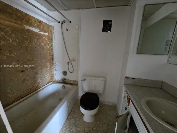 a bathroom with a granite countertop sink a toilet and a bathtub