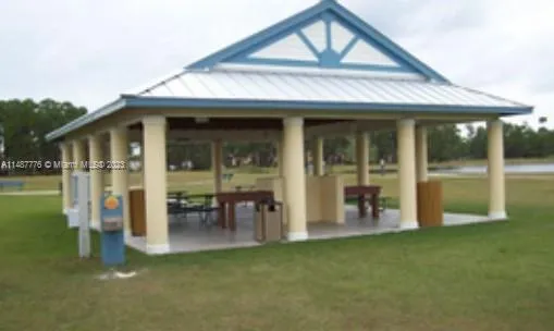 a view of a house with floor to ceiling windows and a lawn chair