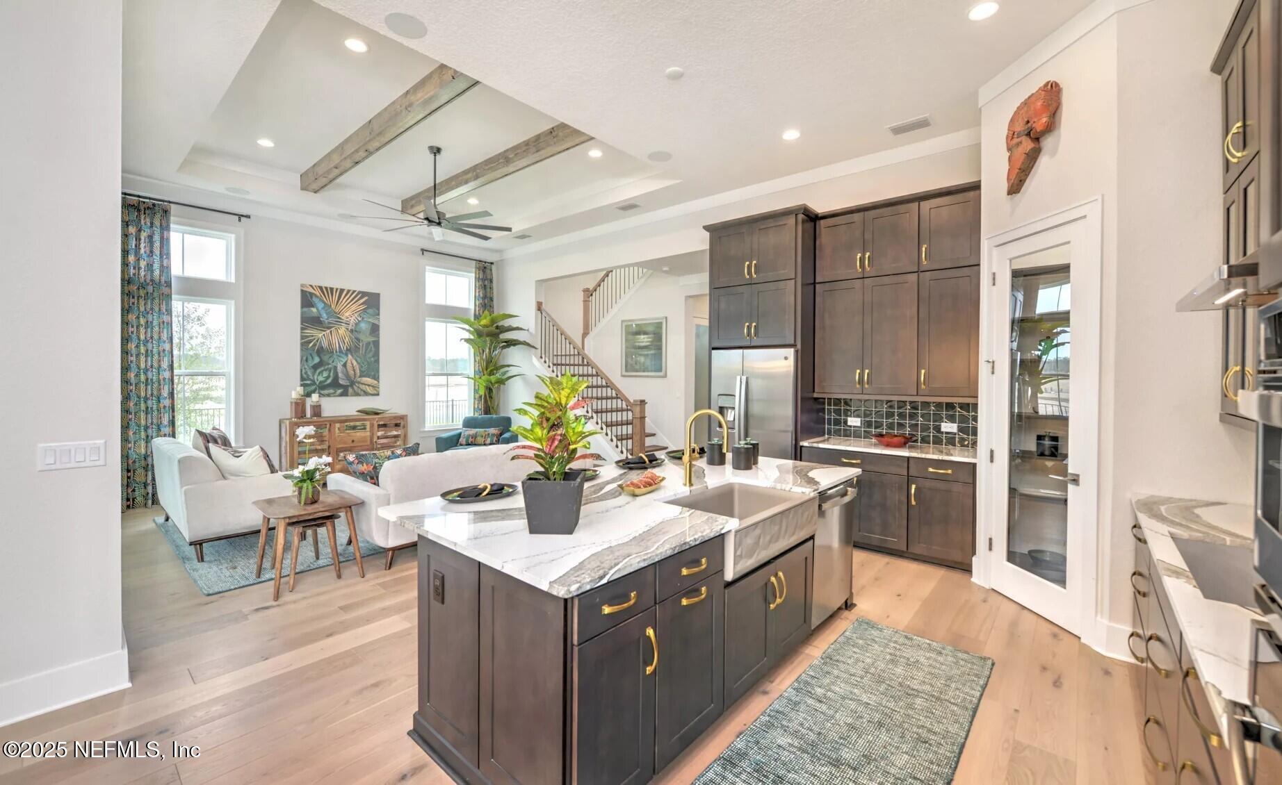 903 Someruelus Street Fernandina Beach, FL 32034 - Photo 7 of 31 a large white kitchen with a large counter top space a sink stainless steel appliances and cabinets