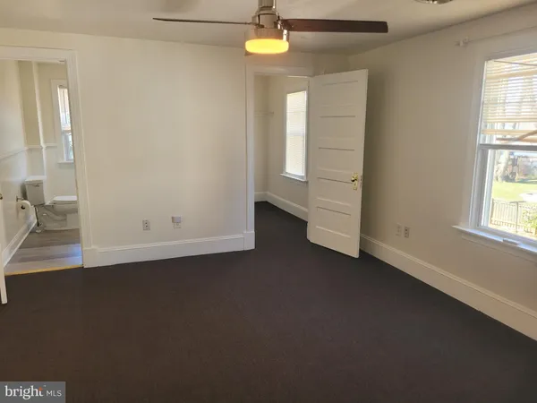 an empty room with windows and closet