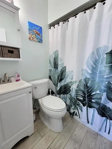 a bathroom with a toilet and a shower curtain