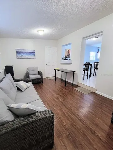 a living room with furniture and a wooden floor