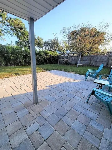 a view of a patio with a table chairs and a yard
