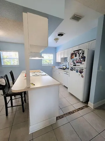 a kitchen with stainless steel appliances kitchen island granite countertop a sink and a refrigerator
