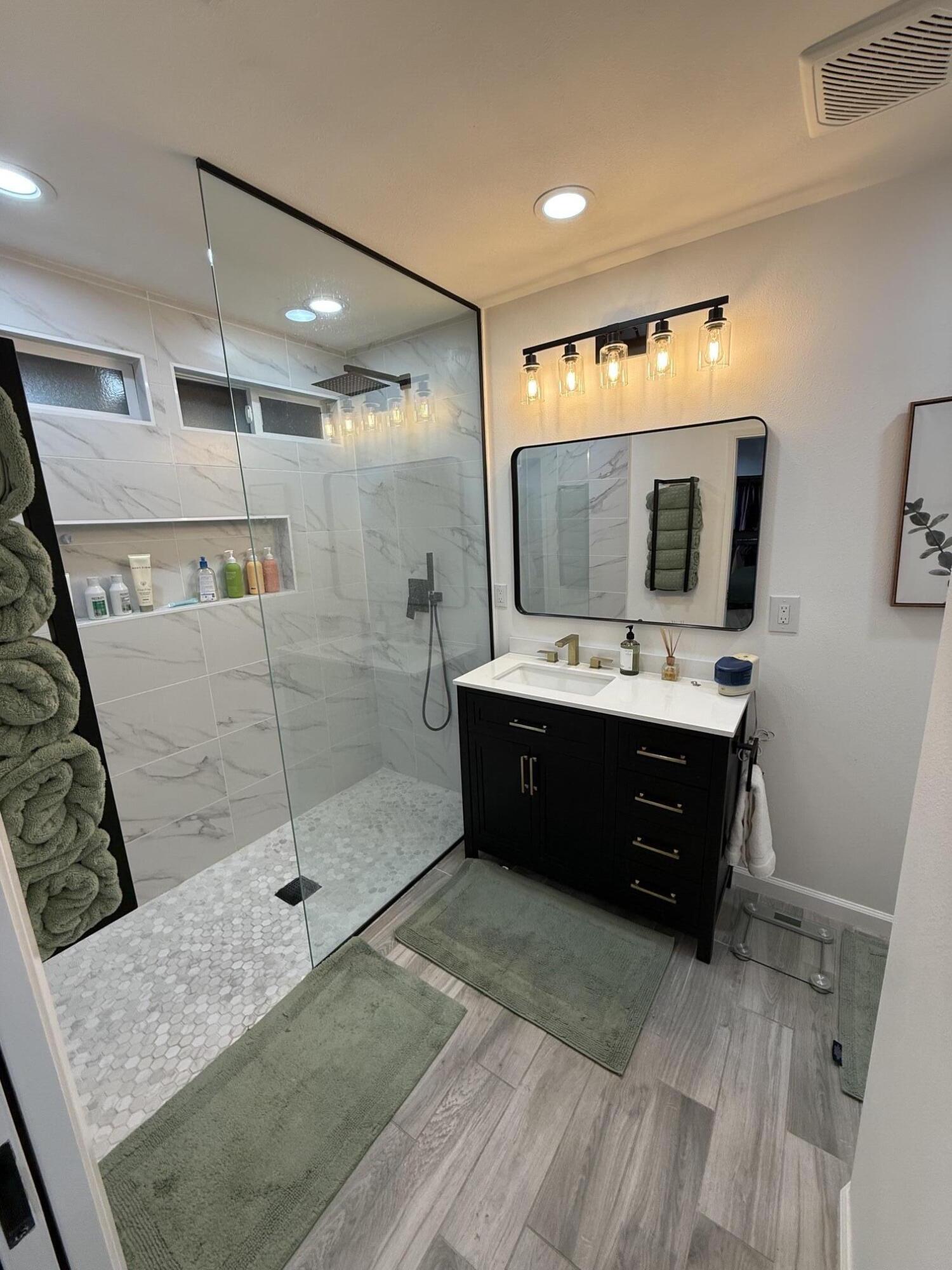 37081 Palmdale Road Rancho Mirage, CA 92270 - Photo 33 of 46 a en suite bathroom with a double vanity sink a mirror and shower