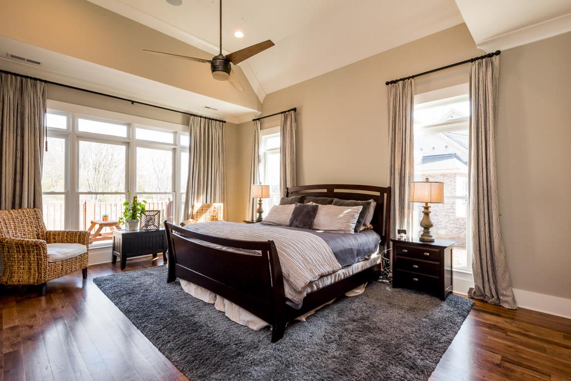 641 Legends Crest Drive Franklin, TN 37069 - Photo 16 of 30 a spacious bedroom with a bed a couch and a large window with wooden floor