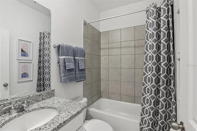 a bathroom with a granite countertop bathtub sink vanity and shower