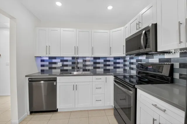 a kitchen with stainless steel appliances granite countertop a stove a sink and a microwave