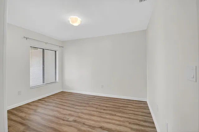 a view of empty room with wooden floor