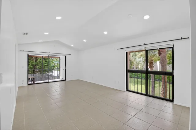 an empty room with large windows and garden