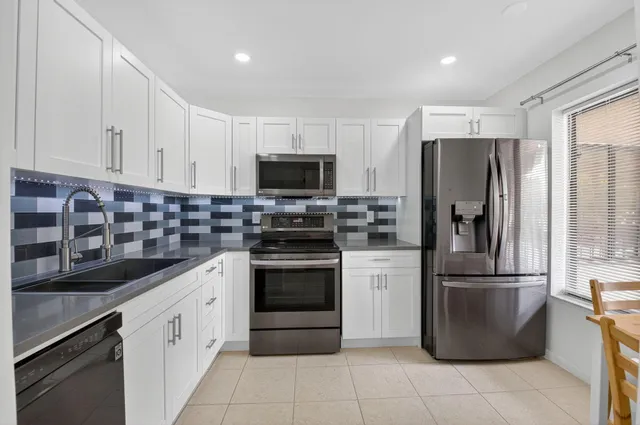 a kitchen with stainless steel appliances granite countertop a refrigerator stove and sink