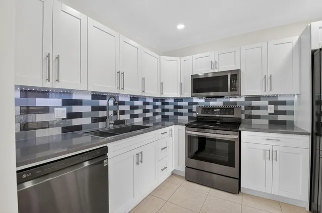 a kitchen with stainless steel appliances granite countertop a sink stove and microwave
