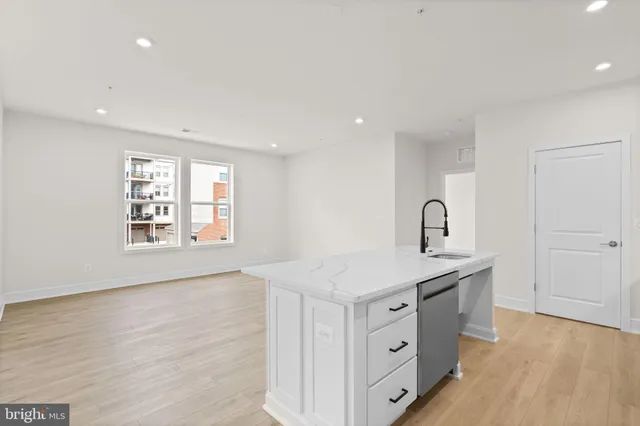 a kitchen with white cabinets and sink