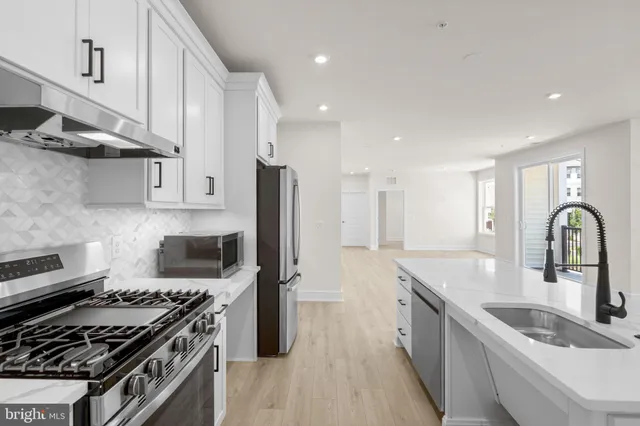 a kitchen with stainless steel appliances a sink stove and refrigerator