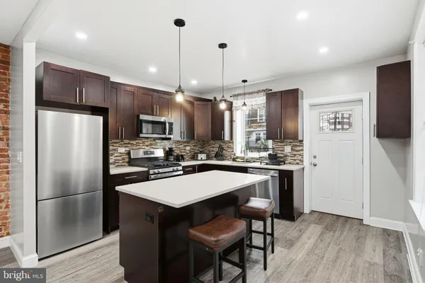 a kitchen with stainless steel appliances a refrigerator a stove a sink and a refrigerator