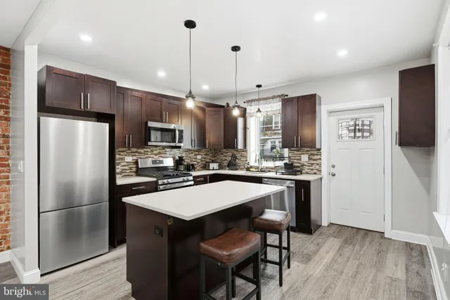 a kitchen with stainless steel appliances a refrigerator a stove a sink and a refrigerator