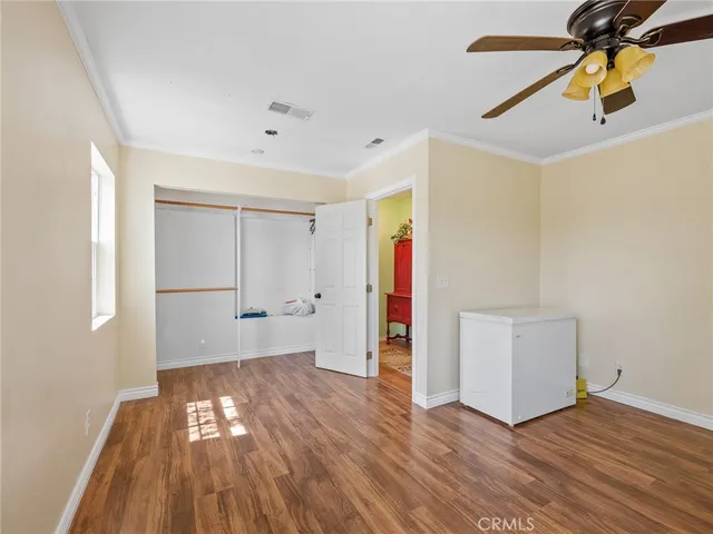a view of room with hardwood floor and a ceiling fan