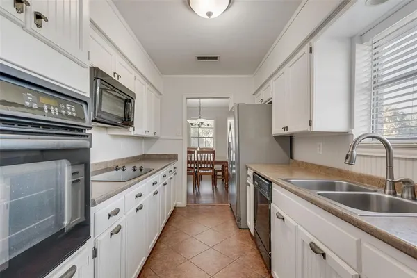 a kitchen with stainless steel appliances granite countertop a stove sink and cabinets
