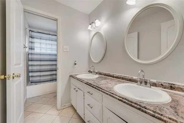a bathroom with a granite countertop double vanity sinks and a mirror