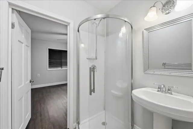 a bathroom with a sink a toilet and shower