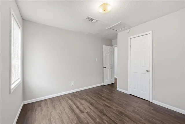 a view of an empty room with wooden floor