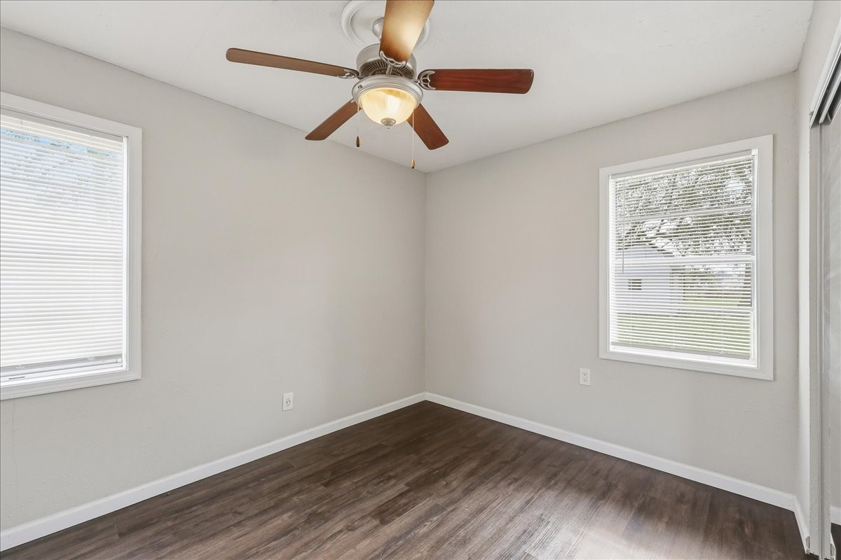 1415 Beagle Road Orange, TX 77632 - Photo 17 of 23 an empty room with wooden floor fan and windows